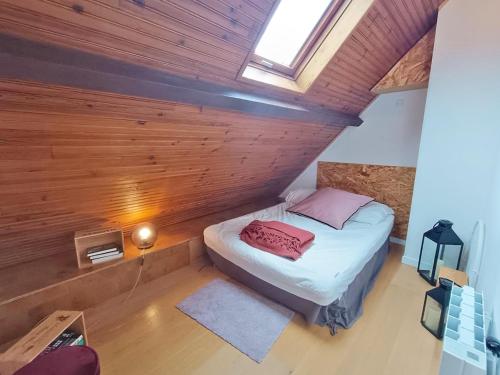une chambre avec un lit dans une pièce aux murs en bois dans l'établissement Le nid de Juliette, T3 duplex, parking, cave, à Luchon