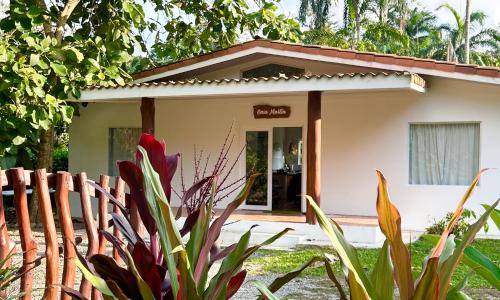ein kleines Haus mit einem Zaun davor in der Unterkunft Casa Martin Cahuita Charming Spanish Home in Cahuita