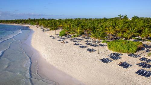 an aerial view of a beach with chairs and palm trees at TRS Yucatan Hotel - Adults Only in Akumal