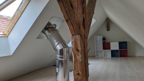 a pole in a attic with a lamp at Tu casita au centre-ville de Rouffach in Rouffach