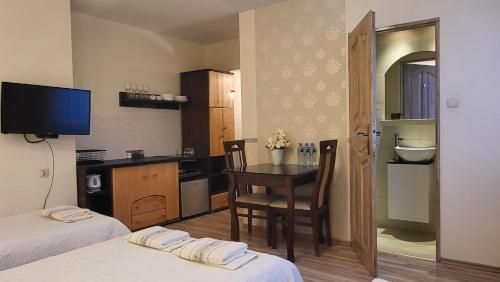 Zimmer mit 2 Betten, einem Schreibtisch und einem Tisch in der Unterkunft Aven'a pokoje gościnne z basenem in Darłowo