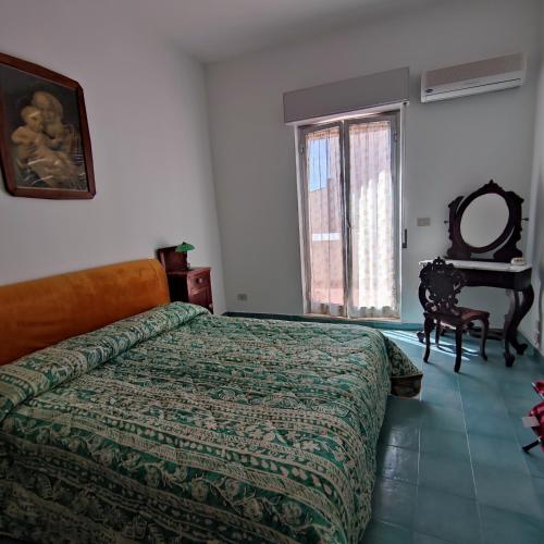 a bedroom with a bed and a window and a table at Casa MAIO, attico molto panoramico, in centro storico in Taormina