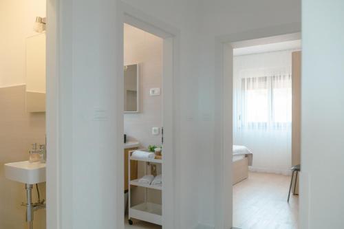 ein weißes Badezimmer mit Waschbecken und Spiegel in der Unterkunft Villa Pava in Zadar