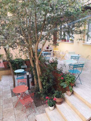 een patio met tafels en stoelen en een boom bij Hotel Minerva in Siena