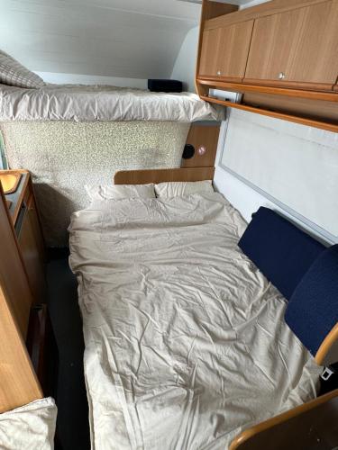 una cama vacía en una habitación pequeña con en Camping Van en Keflavík