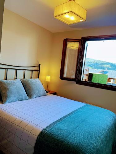 une chambre avec un lit et une grande fenêtre dans l'établissement Apartamento renovado con jardín privado, parking ,wifi y piscina, à Osséja