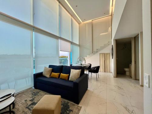 a living room with a blue couch and a table at Marítima Golf Apartment Steps from the Beach in Bucerías