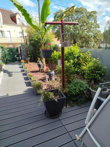 un jardin avec une croix en bois et des oiseaux sur une terrasse dans l'établissement Chambre 2 personnes proche circuit 24h, au Mans
