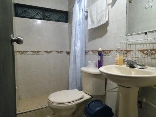 a bathroom with a toilet and a sink at Hostel Lodge la Herradura in San José del Guaviare