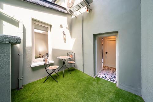 a room with green grass and a table and chairs at Boutique Townhouse in Westport