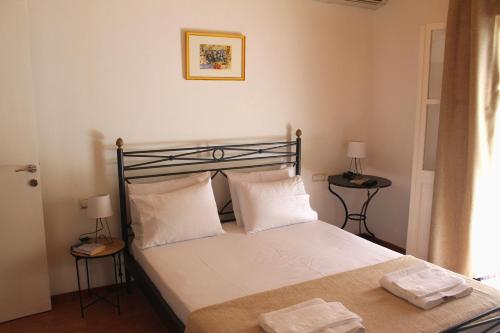 a bedroom with a bed with white sheets and pillows at The Pine Trees in Agnontas