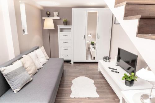 een woonkamer met een bank en een tv bij Bakáts Square Luxury Apartment in Boedapest