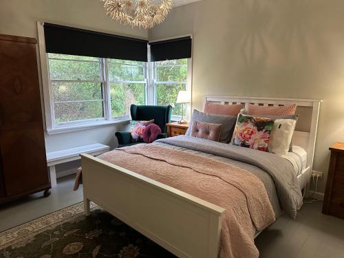 um quarto com uma cama, 2 janelas e um lustre em Bush Retreat Farm Stay 1BR em Alberton West