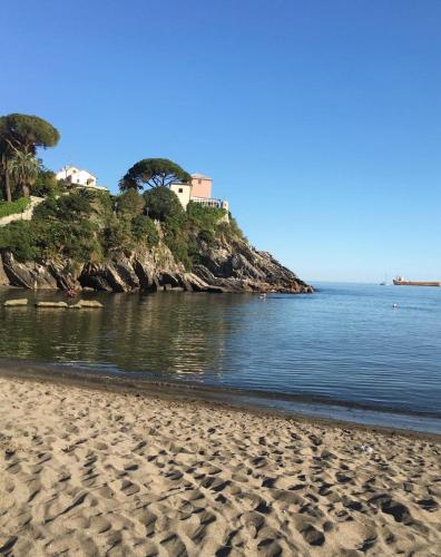 a beach with a house on a hill next to the water at Angolo Di Mare in Genova