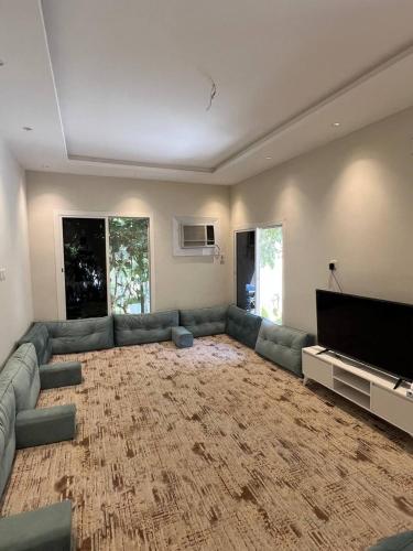 a living room with a couch and a flat screen tv at فيلا اورنيلا in Al Hada