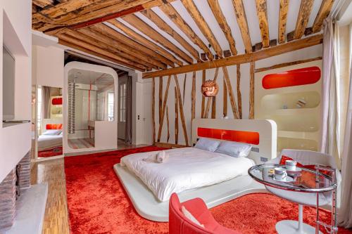 - une chambre avec un lit blanc et une table en verre dans l'établissement Love Nest Jardin du Luxembourg, à Paris