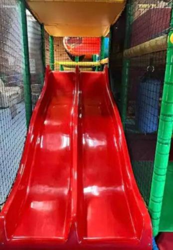 a red plastic seat in a room with a shelf at 44 Gower holiday village Ty Gŵyr Cosy 2 bedroom Chalet with a seasonal indoor pool in Swansea