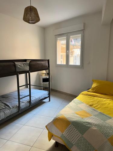 une chambre avec deux lits superposés et une fenêtre dans l'établissement Charmant T3 près du port, à Ajaccio