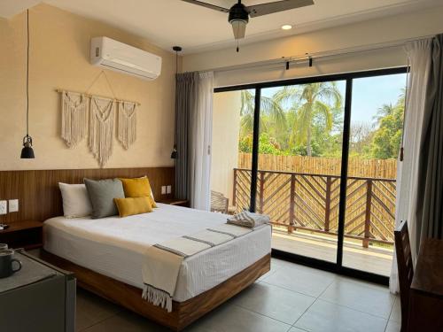 a bedroom with a large bed and a large window at Casa Ita Surf - Adults Only in Puerto Escondido