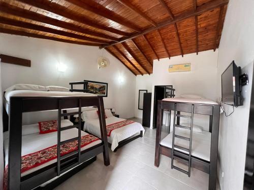a bedroom with two bunk beds and a wooden ceiling at Hotel Cocobana in Necoclí