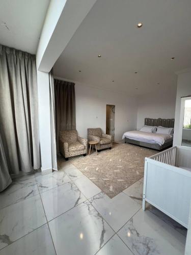 a bedroom with a bed and two chairs in it at فيلا اورنيلا in Al Hada