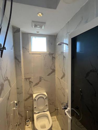 a bathroom with a toilet and a window at فيلا اورنيلا in Al Hada