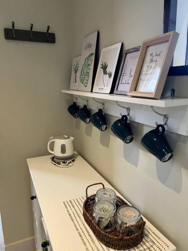 a kitchen counter with a shelf with books and a basket at فيلا اورنيلا in Al Hada