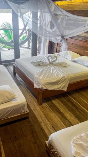a bedroom with two beds with a mosquito net at Hostal MOCAMBO BEACH in Santa Marta
