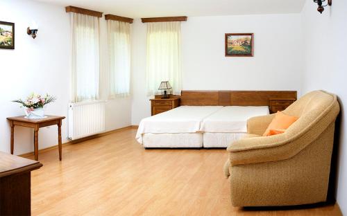 una camera da letto con un letto e una sedia di Strannopriemnitsa Guest House a Bozhentsi