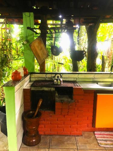 a outdoor kitchen with a stove and a sink at Rancho Caiçara in São Francisco do Sul