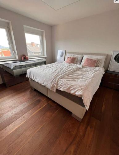 a bedroom with a large bed and two windows at Sonnig zentral gelegene Wohnung in Weiz