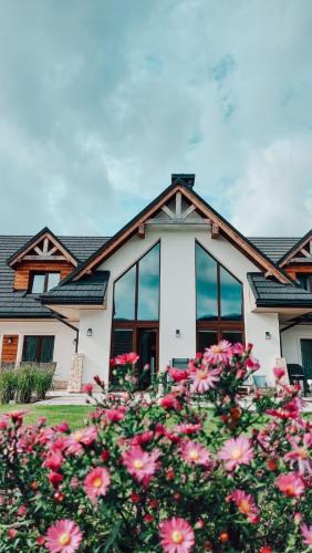 a house with pink flowers in front of it at Apartamenty Otulina in Wetlina
