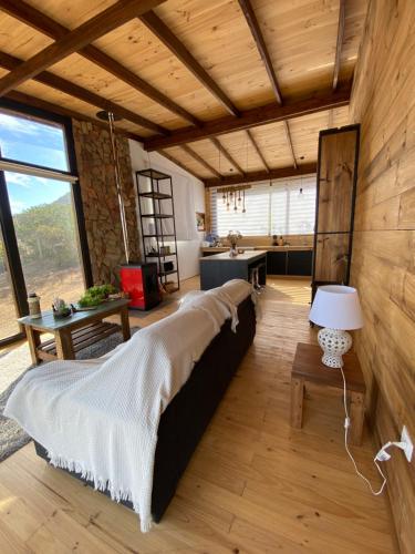a large bed in a room with wooden walls at Cabaña Zen Camino al cristal con la mejor vista desde lo alto a bahía de Pichidangui in Los Vilos