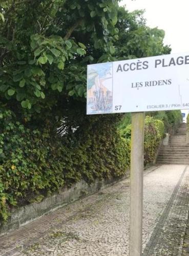 un panneau sur un poteau devant une haie dans l'établissement Sangatte Guest House - Studio Room Sunset - Seafront, à Sangatte