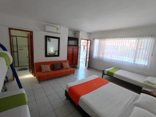 a room with two beds and a couch in it at Hotel Villa Ricaurte in Girardot