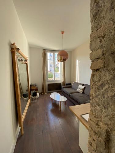 un salon avec un canapé et un mur en pierre dans l'établissement Cozy Apartment Nice Valrose, à Nice