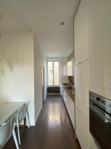 Il comprend une cuisine avec des murs blancs et du parquet. dans l'établissement Cozy Apartment Nice Valrose, à Nice