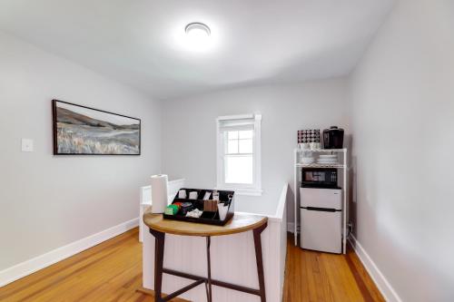 a white kitchen with a table and a refrigerator at Cincinnati Apartment 1 Mi to Hyde Park Square! in Cincinnati