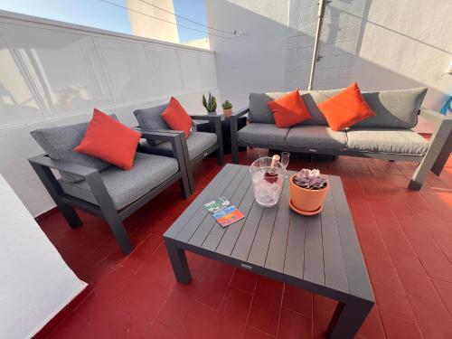 a patio with two couches and a coffee table at Green Apartment in Tavira Garden in Tavira