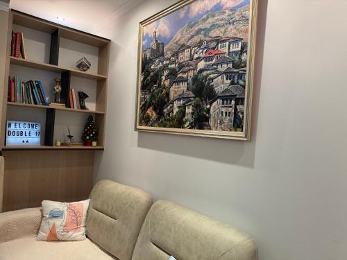 a living room with a couch and a picture on the wall at Double17 Apartaments in Gjirokastër