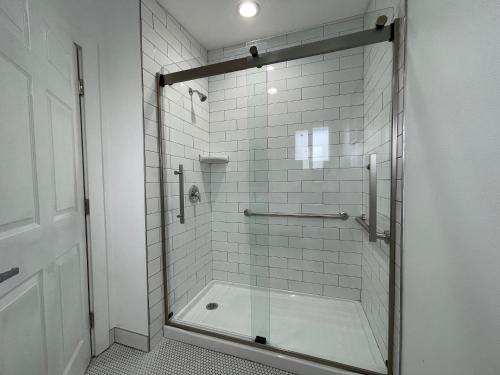 a shower with a glass door in a bathroom at Sunny Sands Inn in Costa Mesa