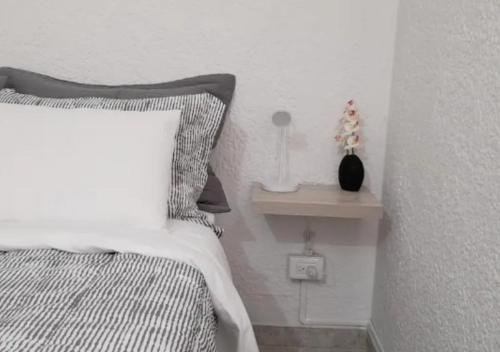 a bedroom with a bed and a side table with a lamp at Habitación 2 Santa Catalina in Floridablanca