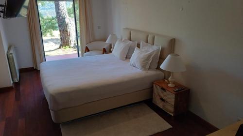 a bedroom with a white bed with a window at Fátima-Ourém - Quinta da Luz - breakfast included in Ourém