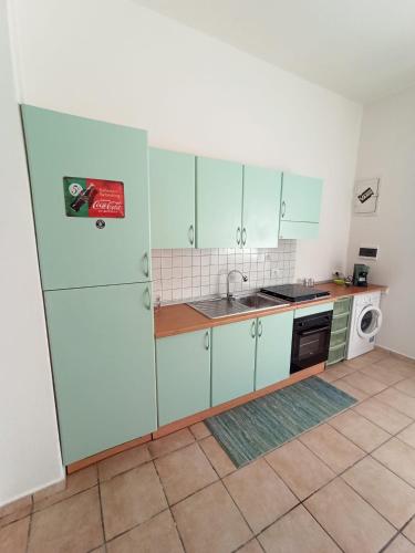 a kitchen with blue cabinets and a sink and a stove at Casa del Papavero in Piombino