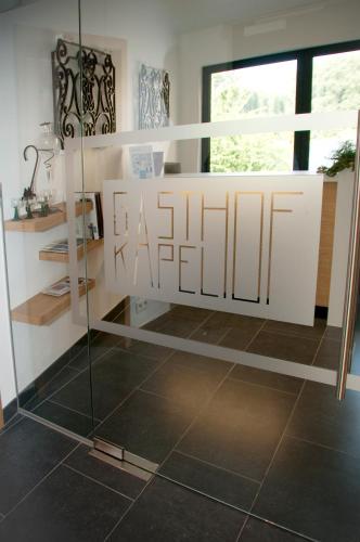 a bathroom with a glass shower stall with a mirror at Hotel Gasthof Kapelhof in Erpe-Mere