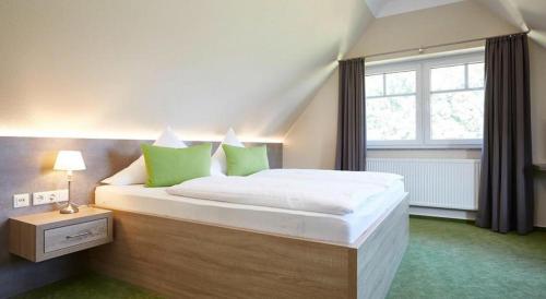 Schlafzimmer mit einem großen Bett und einem Fenster in der Unterkunft Hotel Waldblick Deppe in Lippstadt