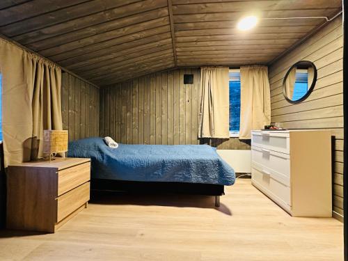 a bedroom with a bed and a dresser and a mirror at Explore Bugøynes in Bugøynes