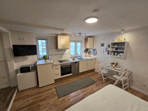 a kitchen with white cabinets and a table in it at Ferienwohnung Casa Orlandini in Bad Reichenhall