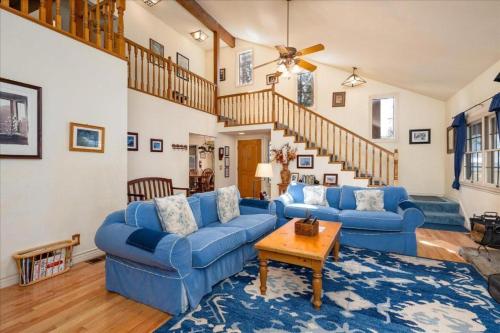 a living room with blue couches and a staircase at Wawona Home in Wawona