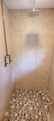 a shower stall with a tiled floor and a shower at Casa Ecológica Al Pie Del Volcán in Otavalo